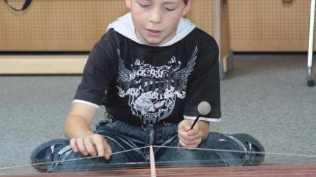 Ein Junge spielt ein Saiteninstrument
